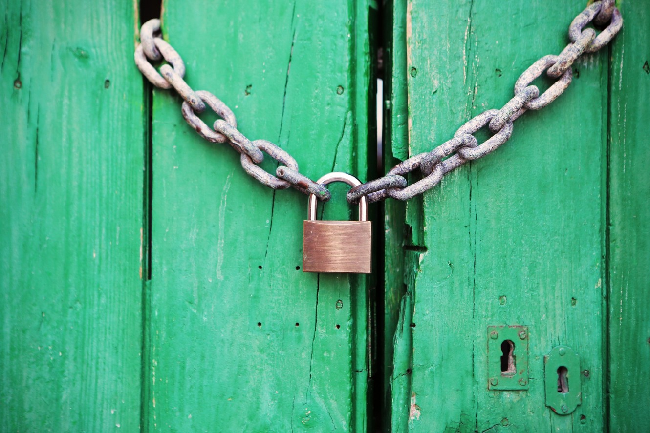 Wood doors painted bright green with chain and padlock.
