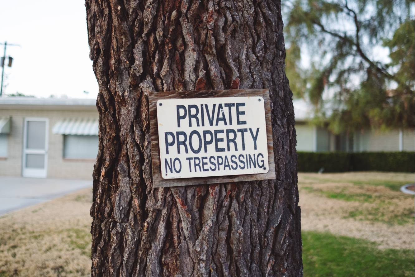 Tree trunk with sign of "Private Property No trespassing".