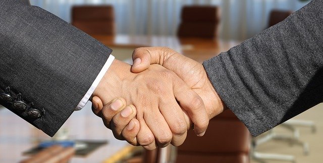 Men in business suits shaking hands.