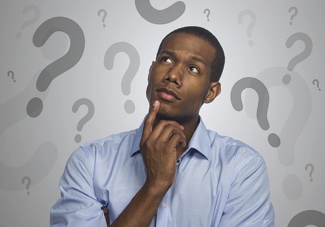 Man in thought with stylized question marks surrounding him.