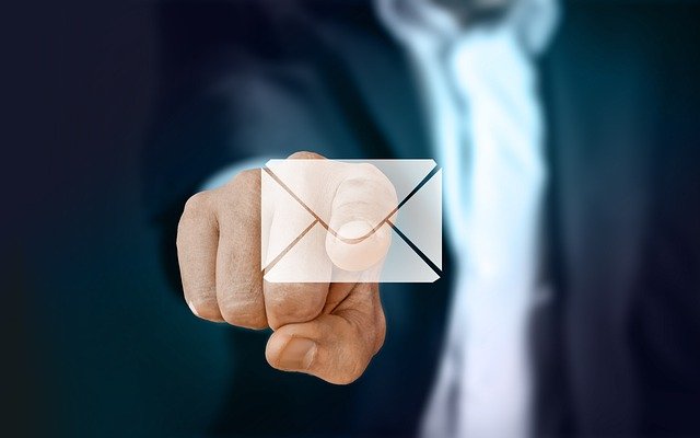 Man in suit with index finger extended to a stylized mail envelope, to indicate "Send Email".